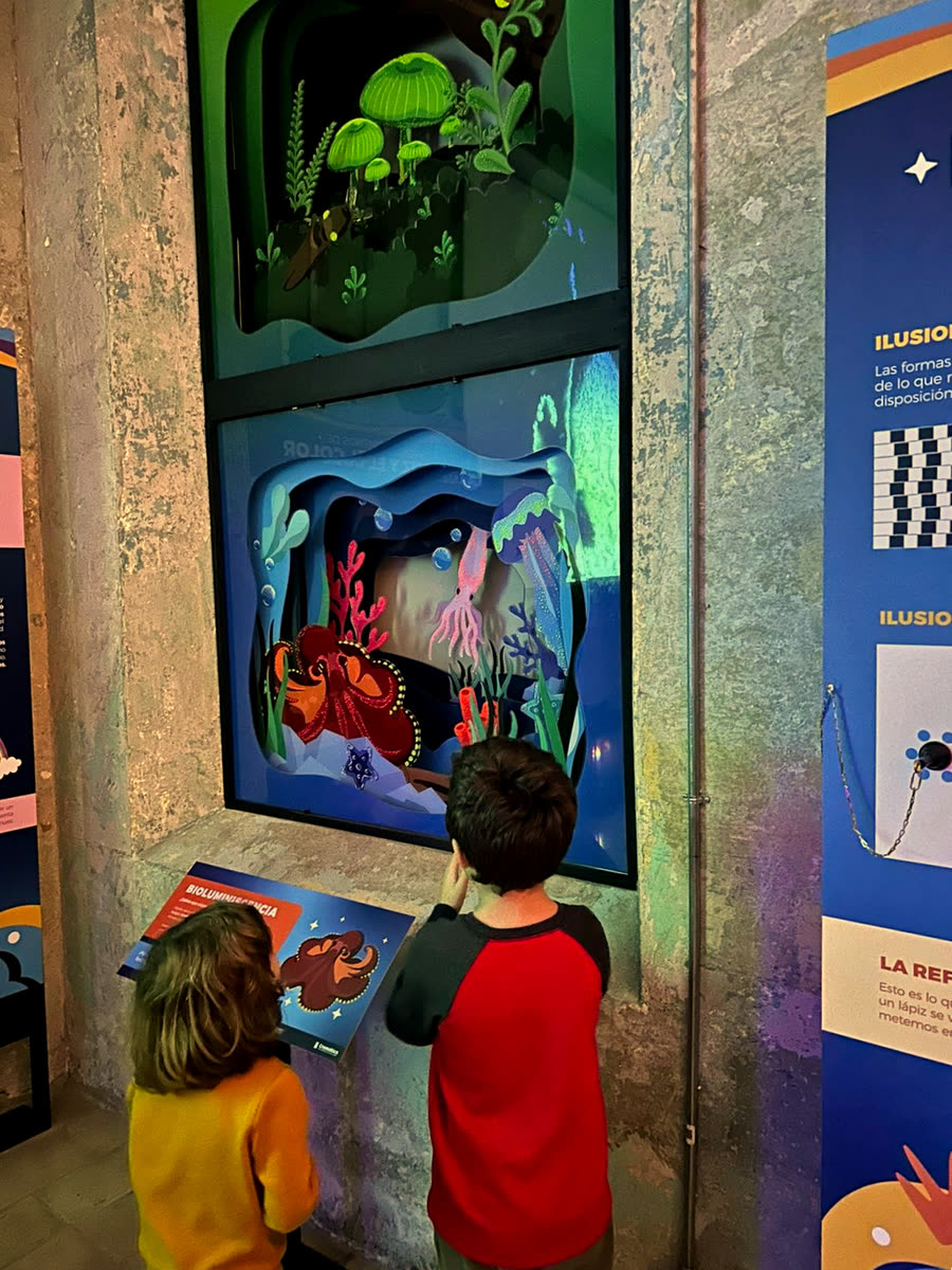 Dos niños frente al diorama de bioluminiscencia, ya en la sala