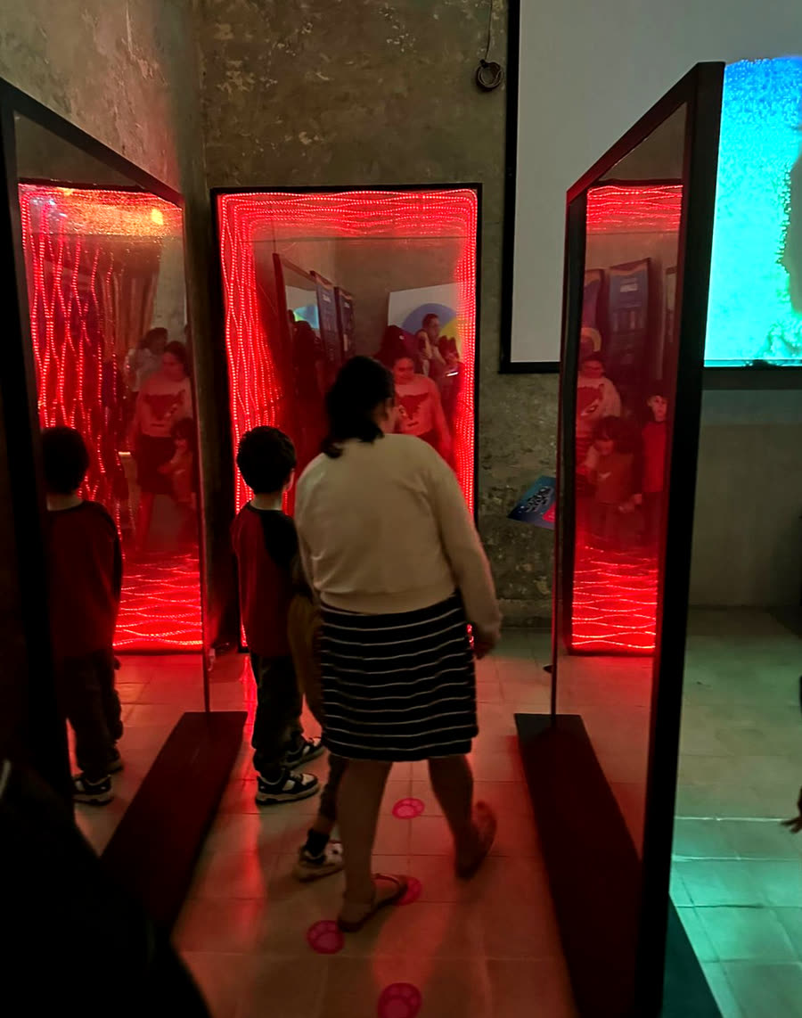 Visitantes entre los espejos infinitos, iluminados de rojo